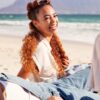 group of women sitting together on beach laughing