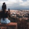 woman enjoying a cityscape from above and taking a photo