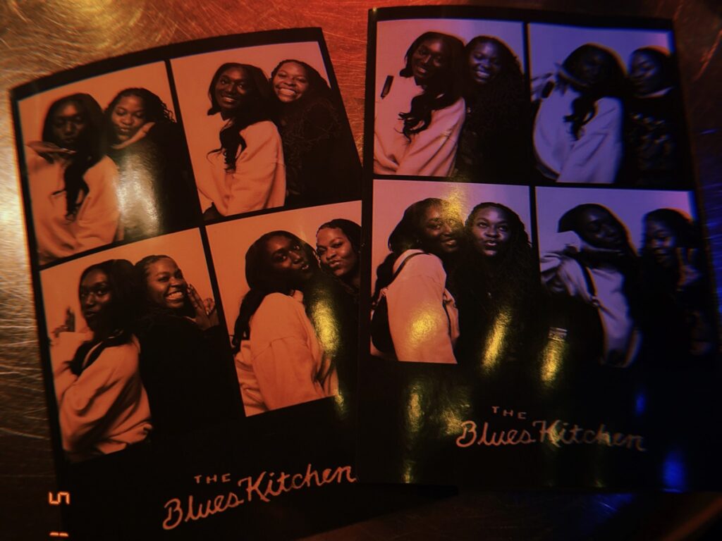 Two Black girls posing in a Photo Booth picture taken at The Blues Kitchen in Camden, London, England.