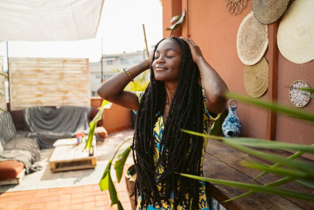 Black woman relaxing on terrace in summer sunlight