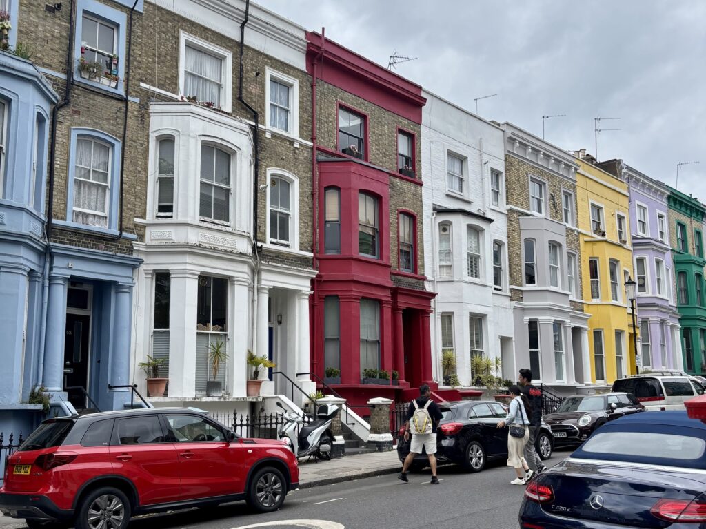 Townhomes in Notting Hill. Homes the colors light blue, white, light yellow, red, grey, lavender, and green.
